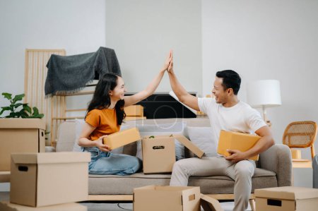 Photo for Asian young attractive couple man and woman use with carton package move in new house. Young married asian moving home - Royalty Free Image