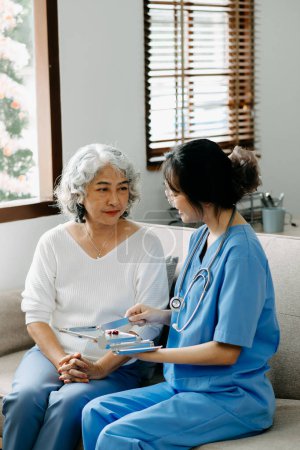 Photo for Senior woman being examined by a doctor in living room - Royalty Free Image
