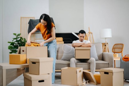 Photo for Asian young attractive couple man and woman use with carton package move in new house. Young married asian moving home - Royalty Free Image