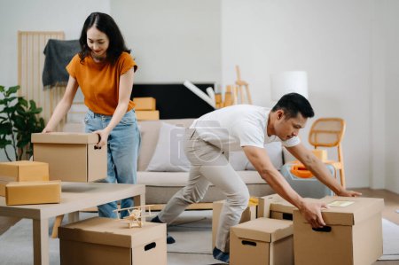 Téléchargez les photos : Jeune couple avec de grandes boîtes emménageant dans une nouvelle maison, nouvel appartement pour couple - en image libre de droit