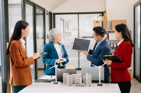 Photo for Business people having consultation about wind energy at company office. Business team discussing about windmill and alternative green energy. Executive meeting at  office - Royalty Free Image