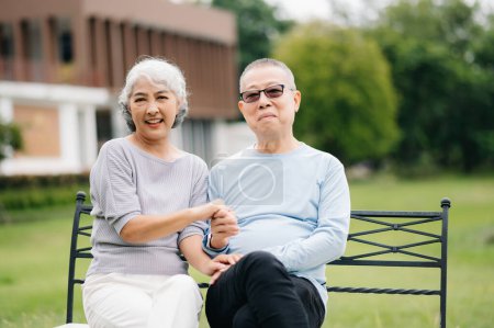 Foto de Asiática pareja de ancianos pasar un buen rato. Se ríen y sonríen mientras están sentados al aire libre en el parque. Preciosa pareja de ancianos - Imagen libre de derechos