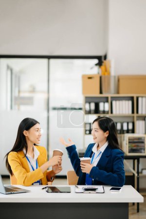 Téléchargez les photos : Heureux deux asiatique femme d'affaires tenant tasse de café dans le bureau de coworking - en image libre de droit