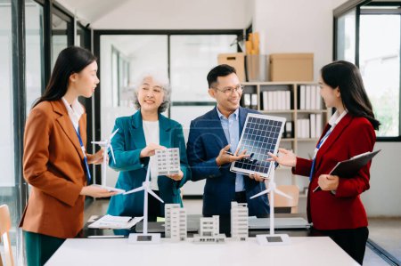 Photo for Group of alternative energy engineers discussing a project with a worker businesspeople a meeting in solar cell panel and Solar Energy Environment city Concept. in office - Royalty Free Image