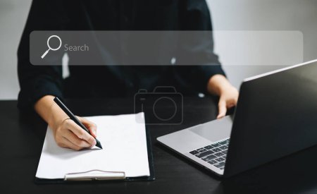Photo for Searching Browsing Internet Data Information Networking Concept with blank search bar. Woman working with mobile phone and laptop computer VR icon in office - Royalty Free Image