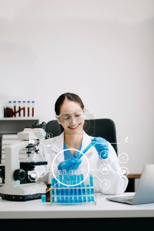 Photo for DNA molecule testing concepts. The doctor in a mask examines DNA molecules on the chemical laboratory with virtual icon - Royalty Free Image