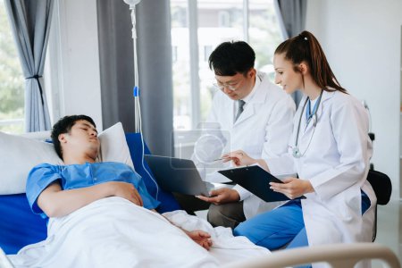 Foto de Dos doctores hablando con un paciente acostado en su cama con solución salina en un hospital moderno - Imagen libre de derechos