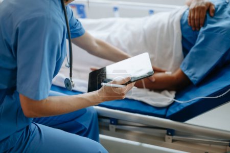 Téléchargez les photos : Médecin discutant du traitement avec un patient masculin assis sur le lit d'examen à la clinique ou à l'hôpital - en image libre de droit