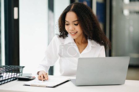 Photo for Confident business expert attractive smiling young woman working on laptop computer at desk in creative office - Royalty Free Image