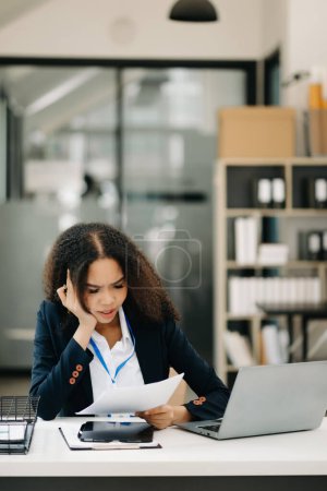 Téléchargez les photos : Asiatique femme d'affaires est stressé, ennuyé, et trop penser de travailler sur une tablette au bureau moderne - en image libre de droit