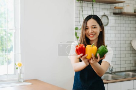 Photo for Fresh bell peppers holding by woman hands mixed salad in home - Royalty Free Image