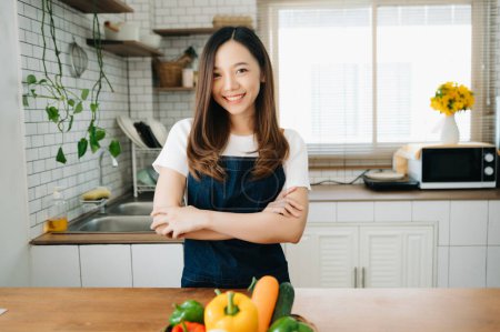 Téléchargez les photos : Image de femme asiatique préparant une salade dans la cuisine et des aliments sains dans un bol à la maison - en image libre de droit