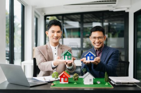 Photo for Salesman and customer with House Model in the office, Small Toy House Small Mortgage Property insurance and concepts real estate - Royalty Free Image