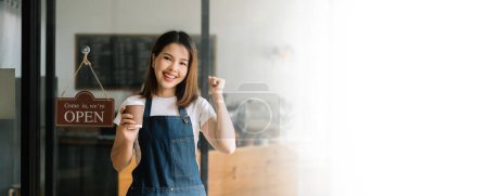 Téléchargez les photos : Jeune femme asiatique propriétaire de café prêt à recevoir des commandes dans le restaurant du café. femme barista café - en image libre de droit