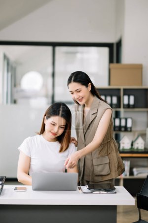 Photo for Two Asian businesswoman  discuss investment project working and planning strategy with tablet laptop computer in modern office. - Royalty Free Image