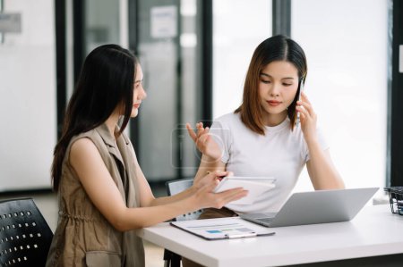 Téléchargez les photos : Deux femmes d'affaires asiatiques discuter projet d'investissement de travail et de la stratégie de planification avec tablette ordinateur portable dans le bureau moderne. - en image libre de droit