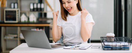 Photo for Asian business woman are delighted and happy with the work on laptop at the office - Royalty Free Image