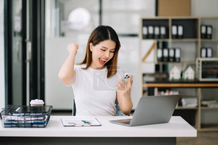 Téléchargez les photos : Asiatique femme d'affaires sont ravis et heureux avec le travail sur ordinateur portable au bureau - en image libre de droit