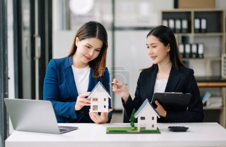 Foto de Salesman Hands On House Model , Small Toy House Small Mortgage Property insurance and concepts real estate in office - Imagen libre de derechos