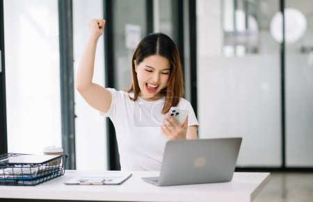 Téléchargez les photos : Asiatique femme d'affaires sont ravis et heureux avec le travail sur ordinateur portable et de prendre des notes au bureau - en image libre de droit