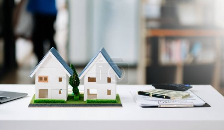 Foto de Equilibrar el sector inmobiliario. el diseño de la casa y el acuerdo de compra. Casa de madera en la oficina moderna - Imagen libre de derechos