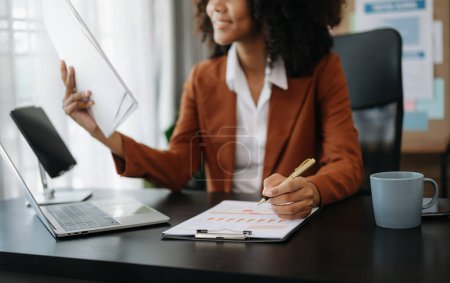 Photo for Business woman using laptop for doing math finance on an office desk, tax, report, accounting, statistics, and analytical research concept in office - Royalty Free Image