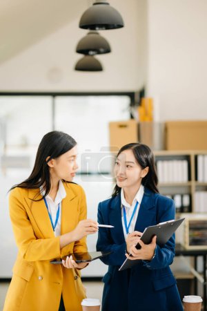 Photo for Two Attractive young Asian female college students working on the school project together - Royalty Free Image