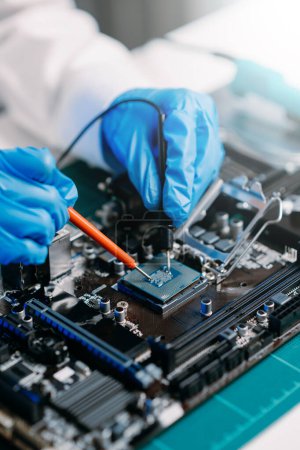 Photo for The technician is putting the CPU on the socket of the computer motherboard. electronic engineering electronic repair, electronics measuring and testing, repair in workshop - Royalty Free Image