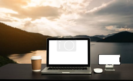 Téléchargez les photos : Moniteur d'ordinateur, clavier, tasse à café et souris avec blanc est sur la table de travail à la rivière de montagne ciel et les arbres vue de face arrière-plan. - en image libre de droit