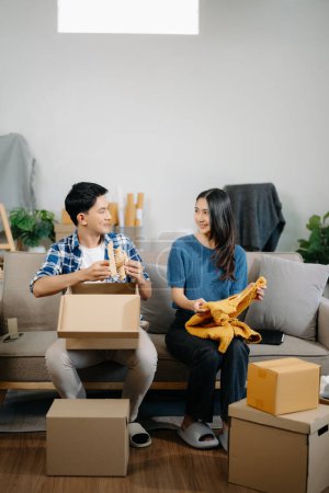 Foto de Pareja joven con grandes cajas mudándose a una casa nueva. Feliz asiático hombre y mujer en casa Interior - Imagen libre de derechos