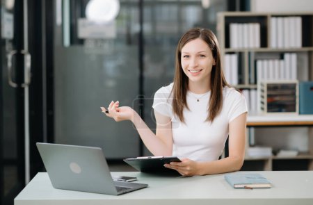 Photo for Confident business expert attractive smiling young woman using laptop on desk in creative office - Royalty Free Image