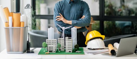 Photo for Businessman with wind energy model at company office. on architectural project site and making model house. Asian industry professional - Royalty Free Image