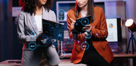 Foto de Dos mujeres que utilizan chatbot en la tableta inteligente inteligencia Ai.Chat con Inteligencia Artificial AI, desarrollado por Open AI generar. Tecnología futurista, robot en sistema en línea. - Imagen libre de derechos