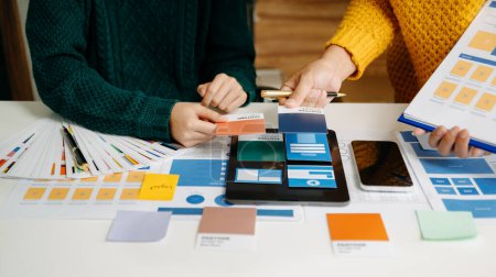 Photo for UX developers and ui designers brainstorming about mobile app interface wireframe design with customer brief and color code at modern office. - Royalty Free Image