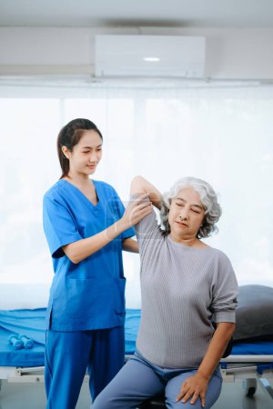 Photo for Female Doctor and patient suffering from back pain during medical exam. on the bed in clini - Royalty Free Image