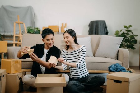 Téléchargez les photos : Asiatique jeune couple attrayant homme et femme dans une nouvelle maison. Jeune marié asiatique déménagement maison. - en image libre de droit