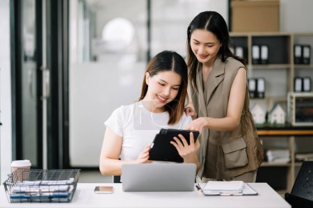 Téléchargez les photos : Deux femmes d'affaires asiatiques discutent de la stratégie de travail et de planification du projet d'investissement dans un bureau moderne. - en image libre de droit