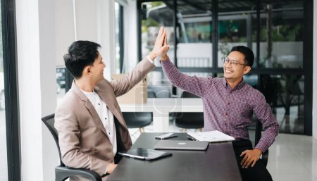 Photo for Two happy businessmen giving high five in office. Successful deal - Royalty Free Image