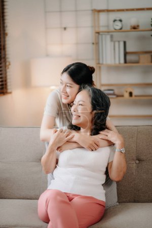 Téléchargez les photos : Heureux asiatique senior grand-mère et jeune petite-fille câlins à la maison - en image libre de droit