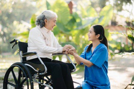 Téléchargez les photos : Jeune asiatique prenant soin de la femme âgée en fauteuil roulant dans le parc de l'hôpital. Concept de soins de santé senior - en image libre de droit