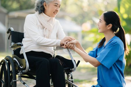 Photo for Elderly asian senior woman on wheelchair with Asian careful caregiver in garden. Senior healthcare concept - Royalty Free Image