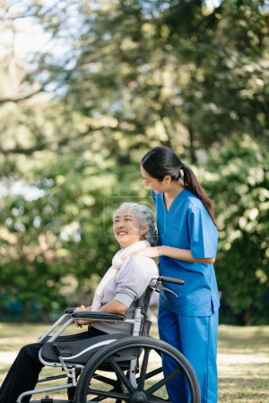 Photo for Elderly asian senior woman on wheelchair with Asian careful caregiver and encourage patient in garden - Royalty Free Image
