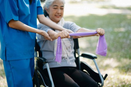 Photo for Asian physiotherapist helping elderly patient with Back problems in the garden. Nursing home hospital garden concept. - Royalty Free Image
