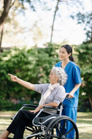 Téléchargez les photos : Asiatique jeune infirmier soignant soutenir les femmes âgées marchant à l'extérieur. Un médecin spécialiste aide et prend soin des personnes âgées matures. Maison de soins infirmiers concept de jardin hôpital - en image libre de droit