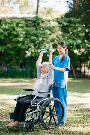 Téléchargez les photos : Kinésithérapeute asiatique aidant patient âgé avec des problèmes de dos dans le jardin. Maison de soins infirmiers concept de jardin hôpital. - en image libre de droit