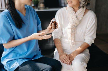 Photo for Asian Doctor explain the use of medication to woman. Medical doctor and patient on sofa at home - Royalty Free Image
