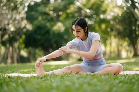 Téléchargez les photos : Portrait de jeune femme pratiquant le yoga dans le jardin.bonheur féminin. dans le parc arrière-plan flou. Style de vie sain et concept de relaxation - en image libre de droit