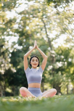 Téléchargez les photos : Portrait de jeune femme pratiquant le yoga dans le jardin.bonheur féminin. dans le parc arrière-plan flou. Style de vie sain et concept de relaxation - en image libre de droit