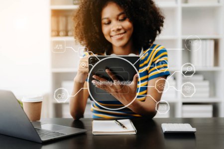Téléchargez les photos : Femme assiste à des leçons en ligne sur une tablette écran virtuel. Formation en ligne et webinaire en ligne. Éducation Internet Technologie. avec icône virtuelle - en image libre de droit