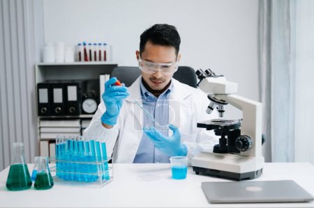Laboratorio de investigación médica moderna. científico masculino que trabaja con micropipetas que analizan muestras bioquímicas, laboratorio químico de ciencia avanzada para la medicina.